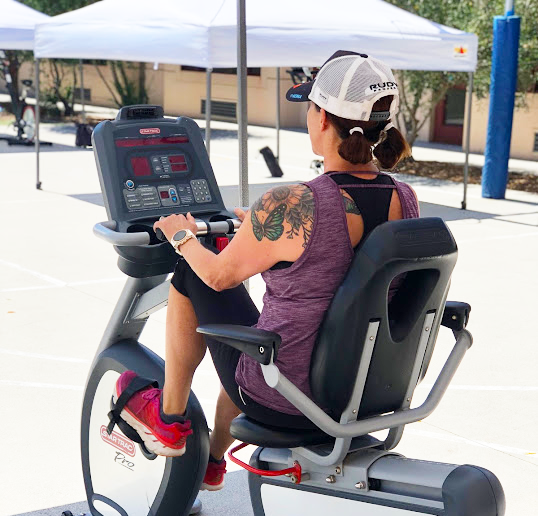 woman at outdoor gym riding fitness bike
