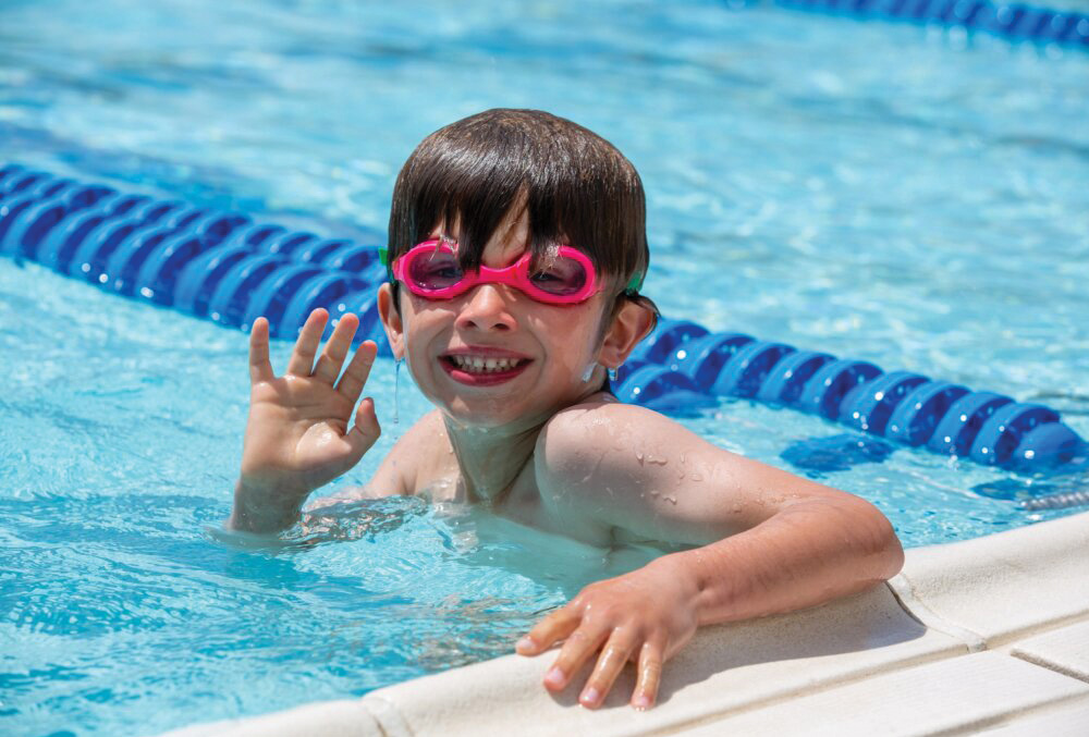 kid with swimming goggles in a pool